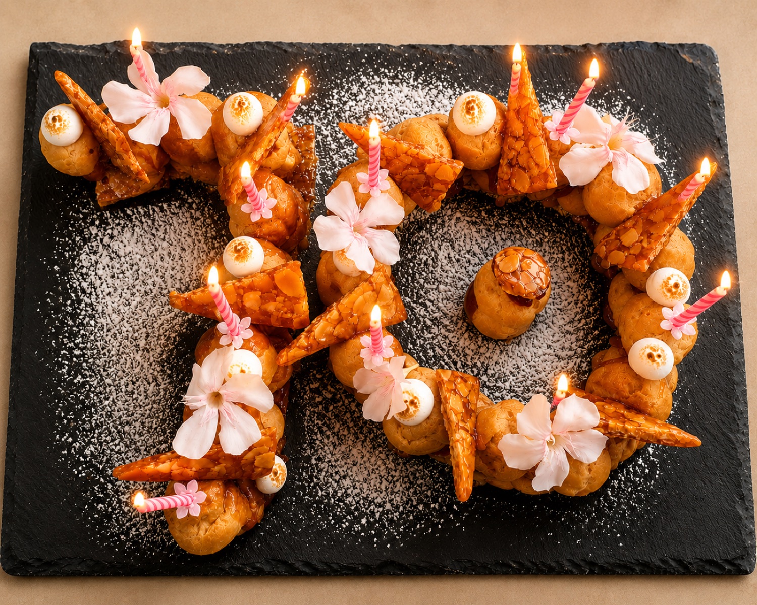 Chiffre « 70 » en choux et nougatine, bougies et fleurs — création de La Craie des Mets